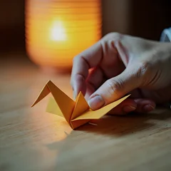 Fotobehang Kraanvogels Holding a Golden Paper Crane near a Warm Lantern  © 和コネクトAI