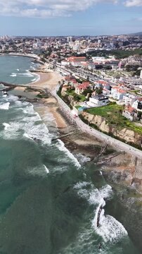 Top-down drone shot of a sunny Estoril promenade, coastal town, and Atlantic ocean near Lisbon
