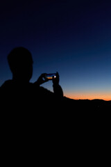 Amateur astronomer with smartphone photographing and observing stars, planets, Moon and other celestial objects. © astrosystem