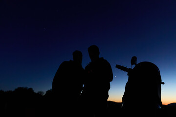 Amateur astronomers observing stars, planets, Moon and other celestial objects with a telescope in nature. © astrosystem