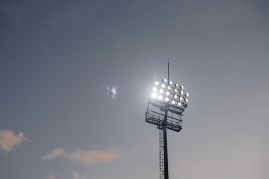 Football stadium floodlights shining at night, soccer match atmosphere and sports stadium illumination concept