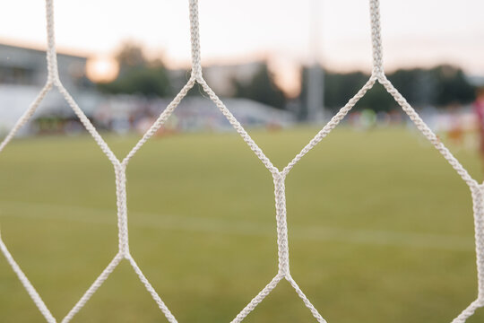 Football net detail close-up, soccer goal mesh on green grass field and sports competition concept