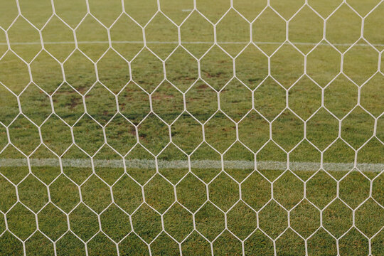 Football net detail close-up, soccer goal mesh on green grass field and sports competition concept