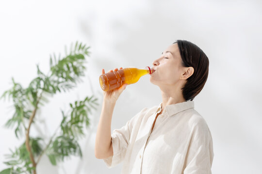 ペットボトルのお茶を飲む女性
