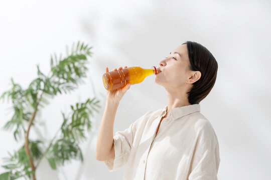 ペットボトルのお茶を飲む女性