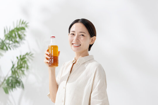 ペットボトルのお茶を飲む女性