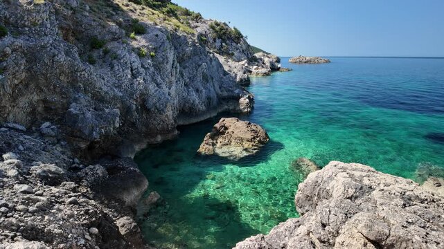 Sveti Ivan Beach on Croatia's Cres Island reveals shimmering blue-green Adriatic waters, vibrant Mediterranean hillsides, and several anchored boats floating peacefully near untouched rocky shoreline.