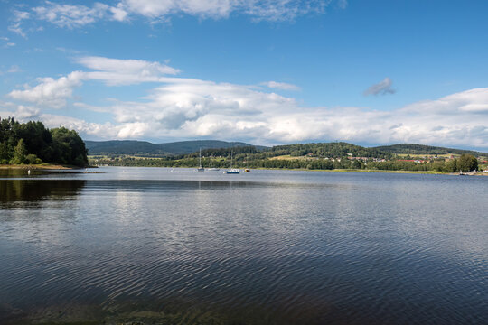 Panoramic view across Lake Lipno with calm water and blue summer sky in South Bohemia, Czech Republic