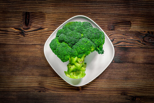 green fresh broccoli for fitness diet food on wooden table background top view