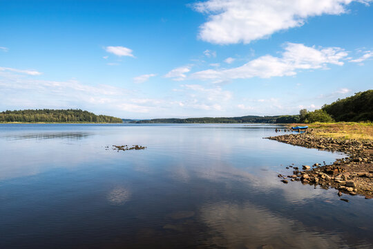 Panoramic view across Lake Lipno with calm water and blue summer sky in South Bohemia, Czech Republic