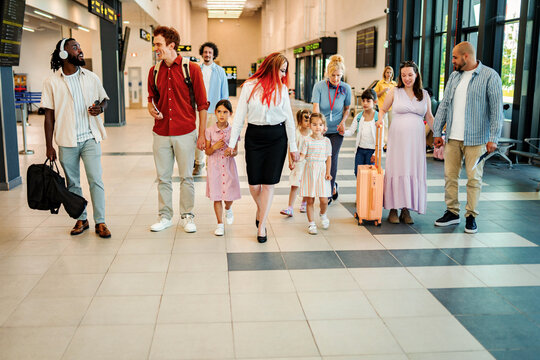 Diverse group of people traveling through a busy airport terminal