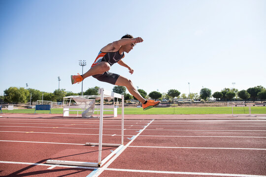 Athlete clearing hurdle during a race