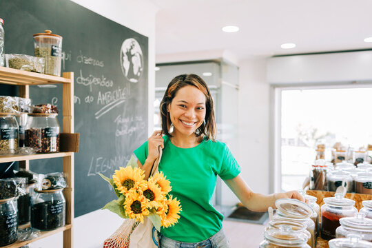 Customer shopping in a zero waste grocery store with sunflowers