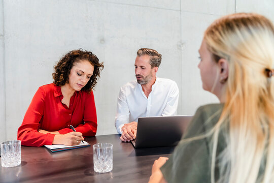 Job interviewer writing on paper in interview at office