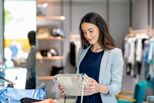 Young woman holding purse while shopping in store