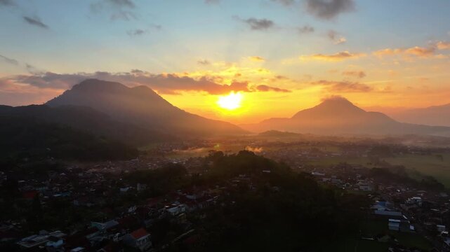 Aerial view of sunrise over mountains and the town of Kadungora, West Java, Indonesia.