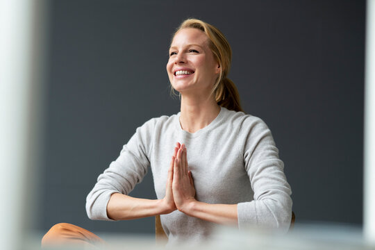 Happy young woman with clasped hands