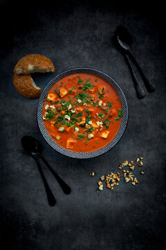 Bowl of Indian halloumi korma curry with bread and roasted cashew