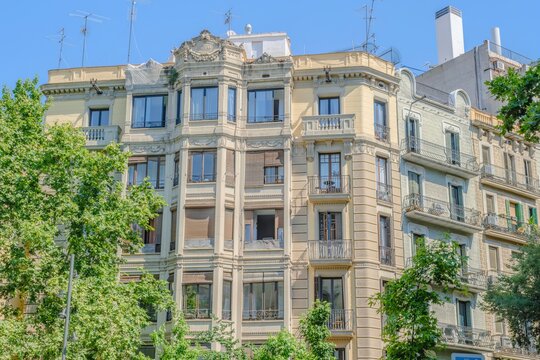 Residential Building Facade in Barcelona, Ornate Stone Balconies, Bay Windows, Antennas on Roof