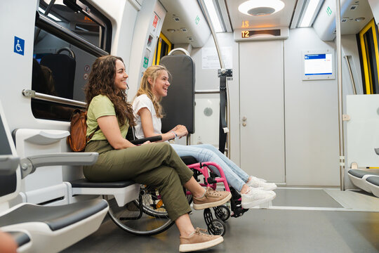 Female friends commuting together on an accessible metro train