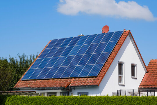 House with tiled roof covered with solar panels