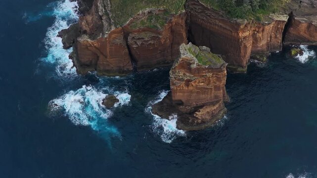 Aerial view of the volcanic Ilheu de Vila Franca do Campo islet with rugged cliffs and crashing waves in the Atlantic Ocean in Sao Pedro, Acores, Portugal.
