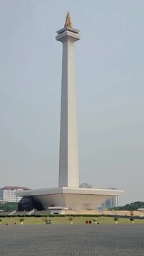 A steady shot of the Monas (National Monument) in Jakarta, featuring the vast plaza and an expansive view under bright sunlight.