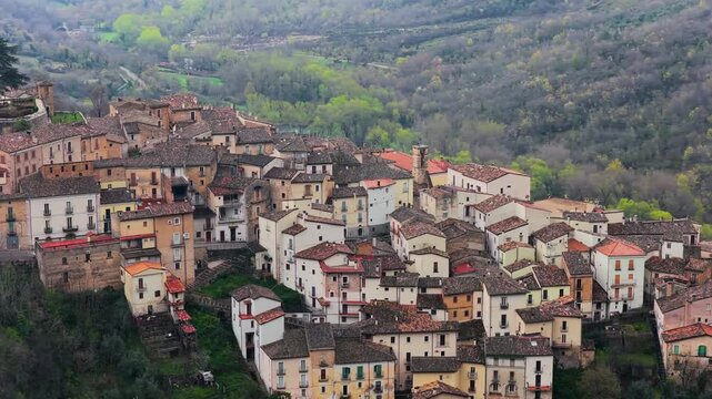 Aerial view of the historic village of Anversa degli Abruzzi with stone houses, terracotta rooftops, and lush green hills in Anversa degli Abruzzi, Abruzzo, Italy.
