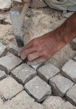 Bricklayer fixing portuguese pavement