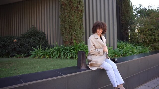 A Stylish Young Woman Leisurely Relaxing in the Outdoor Urban Environment, Exuding Confidence