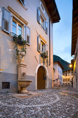 Naklejka premium Ala: Piazzetta del Mandolin, with its fountain set amongst the old houses. Trentino, Italy.