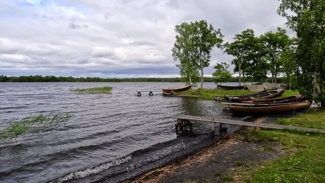 Woodland lake with rustic wooden boats and cabin.