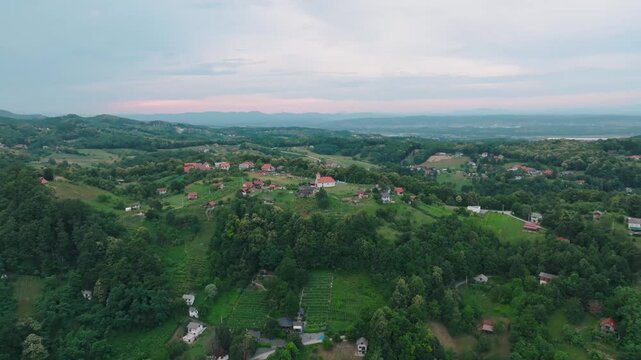 Aerial view of Kurija Hamor surrounded by lush green hills and rural houses in Samobor, Zagrebacka zupanija, Croatia.