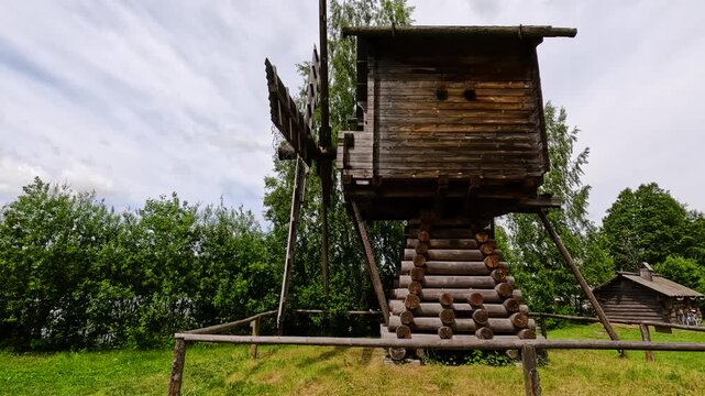 Wooden windmill by a lake.