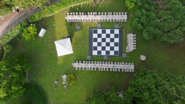Aerial view of Kurija Hamor Samobor with a large chessboard floor and long dining tables set up on the green lawn in Samobor, Zagrebacka zupanija, Croatia.