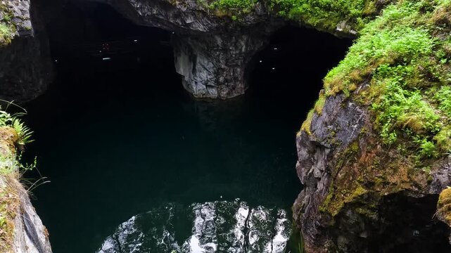 Quarry lake reflecting forest and cliffs.