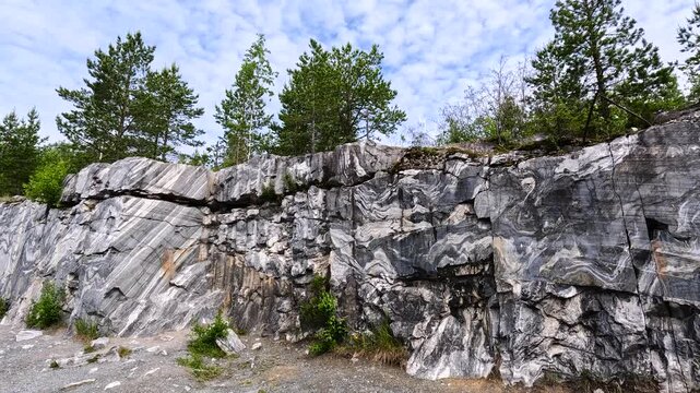 Rock quarry with stratified stone walls.