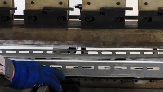 Work on a CNC bending machine in a factory.