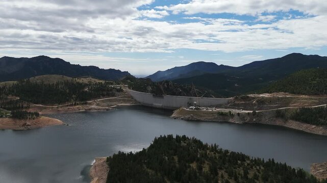 Aerial view of Gross Reservoir surrounded by pine forests and mountains in Boulder County, Colorado, United States.