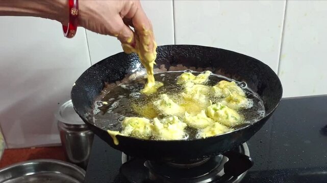 Deep Frying Indian Pakora Fritters in Hot Oil in Wok Kadhai Close Up