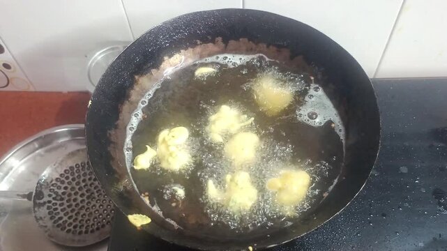 Deep Frying Indian Pakora Fritters in Hot Oil in Wok Kadhai Close Up