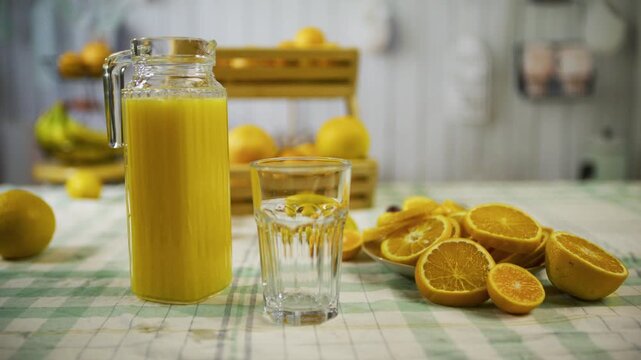 Sliced oranges and pitcher on kitchen counter - cinematic medium tracking shot