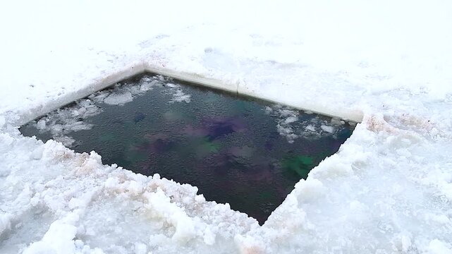 Hole in the ice carved out for swimming, hardening winter.