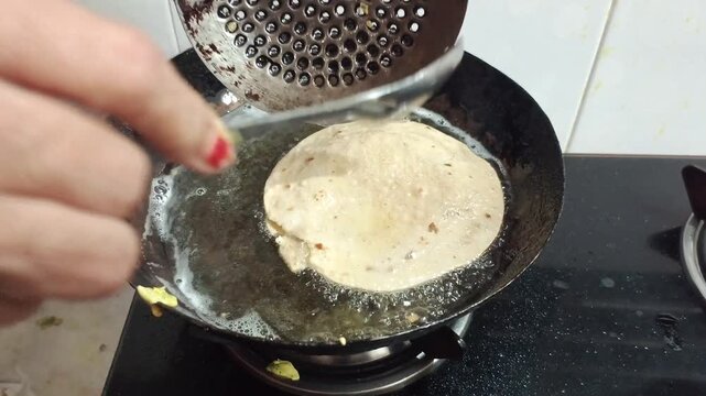Deep Frying Indian Puri Bread in Hot Oil in Wok Kadhai Close Up