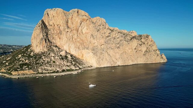 Aerial view of the massive Penyal d'Ifac limestone rock formation rising from the Mediterranean Sea along the coastline of Calp, Valencian Community, Spain.