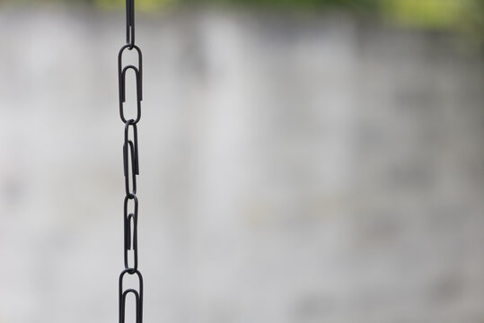 Black paper clips linking together creating strong chain