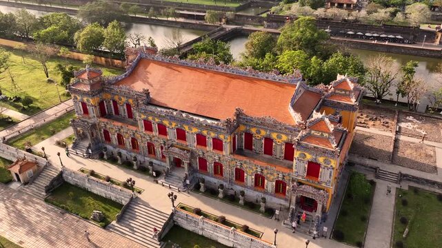 Kien Trung Palace in Hue Imperial City with a vibrant yellow facade, red shutters and roof details. Aerial Drone Shot