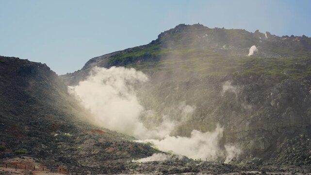 Volcanic gas and sulfur steam vents emitting fumes from the rocky ground of an active stratovolcano in Akan Mashu National Park, Hokkaido, Japan, showing powerful geothermal energy