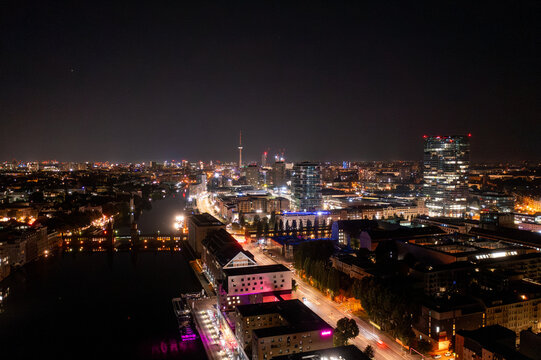 Aerial view of the Oberbaum Bridge spanning the Spree river with the illuminated Berlin skyline at night in Berlin, Berlin, Germany.