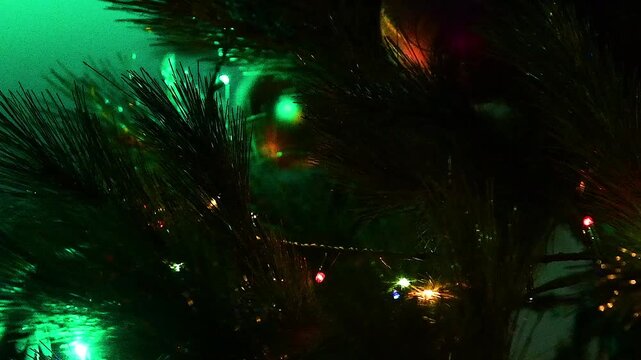 A Christmas tree decorated with various toys, garlands and lights hanging from its branches.